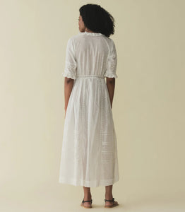 Crafted from the softest organic cotton voile, the Victorian-inspired Rosabella Dress features a plunging V-neckline framed with cascading scalloped lace-trimmed ruffles that extend down the bodice. Alternating panels of inset lace, clustered pintucks, and intricate bow embroidery adorn the front, back, and elbow-length sleeves. A line of hand-crocheted buttons run down the front, while inset lace decorates a fitted waist and ankle-grazing skirt.