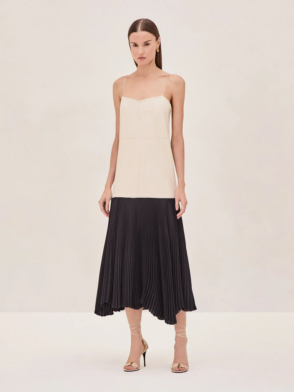 Discover the Piatta Midi by Alexis - a stunning fusion of sleek and sophisticated. Crafted with vegan leather and a flowy pleated skirt for a striking contrast. Delicate spaghetti straps and a flowing midi length exude modern elegance. A must-have for effortless chic.