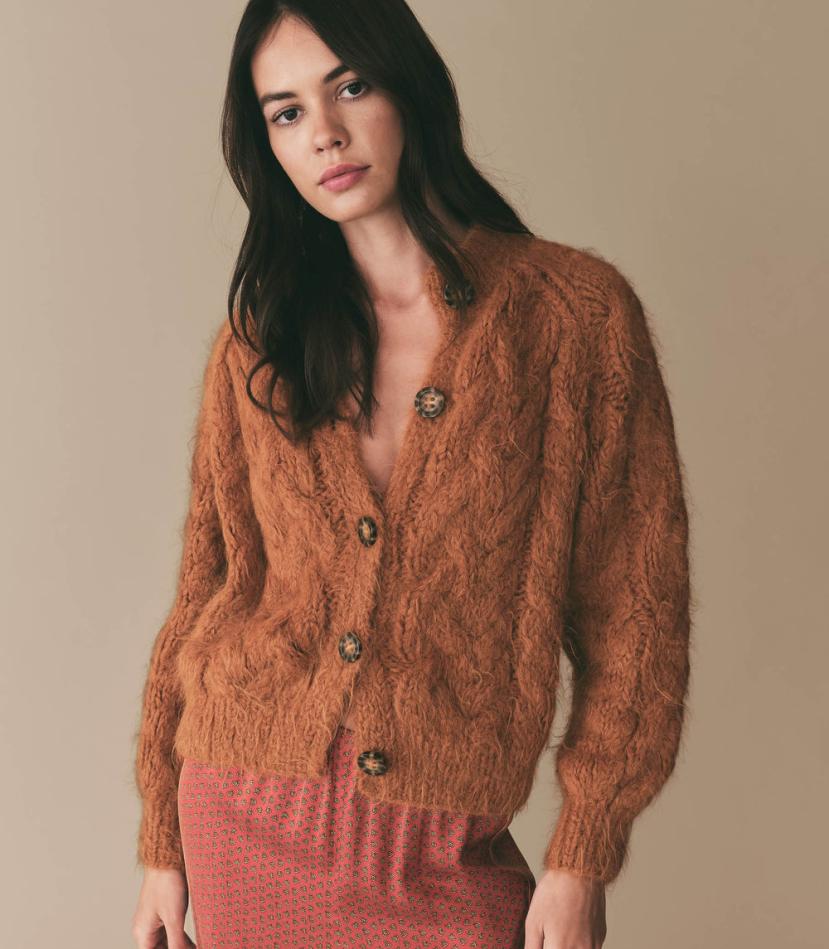 Elevate your wardrobe with the luxurious comfort and style of the Adelina Cardigan. Handknit by skilled artisans in Peru using a soft Peruvian alpaca blend, this cardigan boasts a relaxed silhouette and full-length raglan sleeves. The classic cable knit design, faux tortoiseshell buttons, and ribbing add texture to this must-have piece.