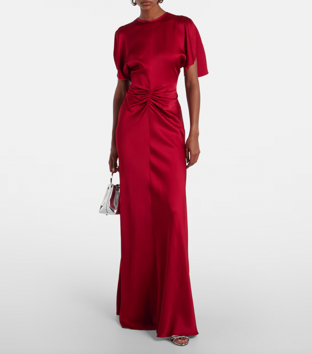 Stunning in vibrant red crêpe satin, this Victoria Beckham gown masterfully balances elegance with edge. Dramatic cape shoulders provide modest coverage while the daring open back commands attention—a sophisticated contrast that turns heads. Expertly gathered detailing sculpts a flattering hourglass silhouette, making this the perfect statement piece for unforgettable evenings. Timeless design meets modern allure.