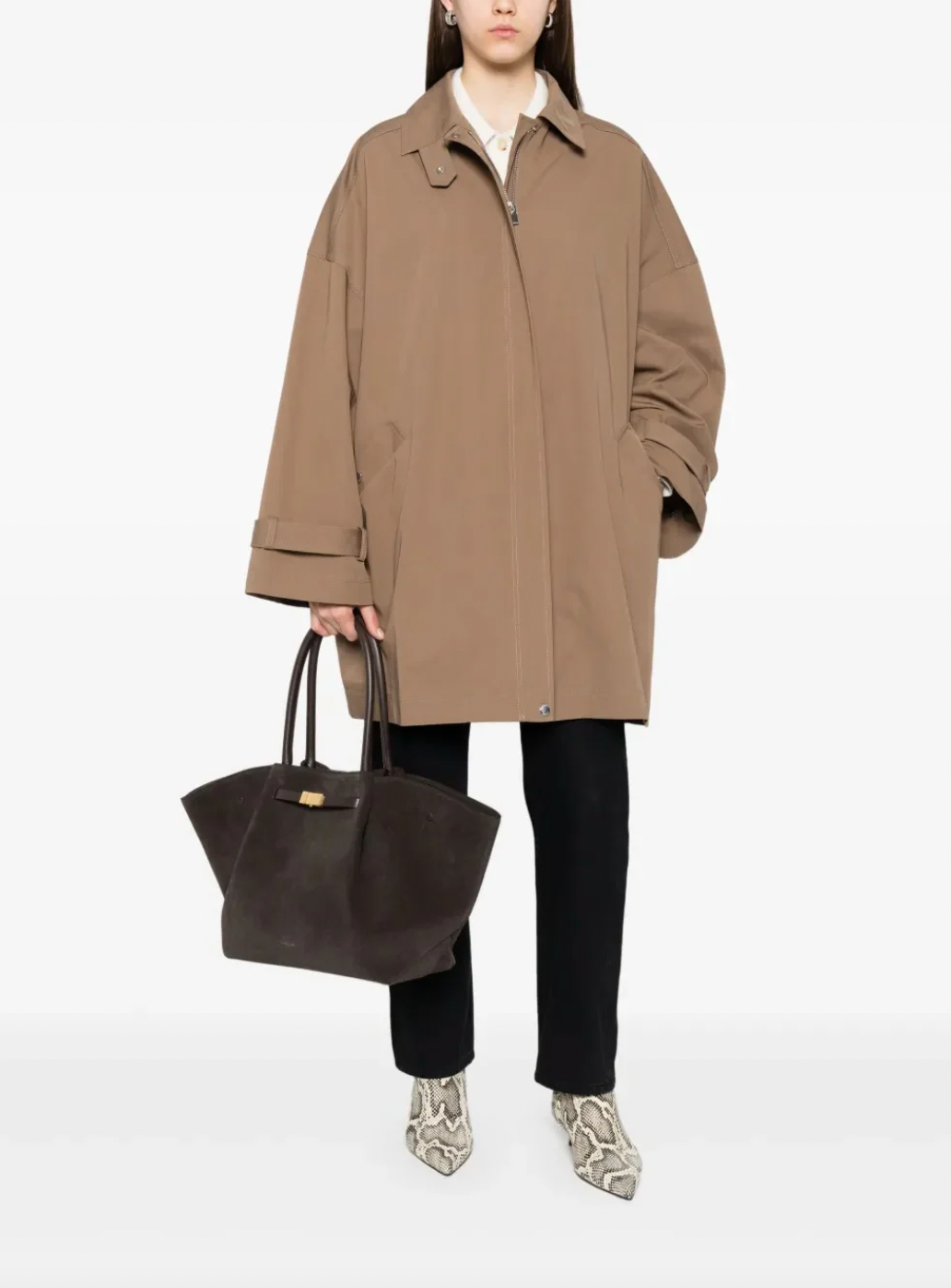 Elevate your everyday style with this hazel brown oversized trench jacket by Toteme — a timeless piece that effortlessly transitions from office to weekend. The classic collar and concealed front zip create a sleek silhouette, while belted cuffs add refined detail and adjustability. Practical side welt pockets keep essentials within reach without disrupting the polished line. Perfect for layering or wearing solo, this relaxed-fit jacket delivers sophisticated versatility that works season after season.