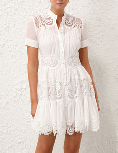 This cotton mini dress features short sleeves and a front center placket for a polished look. Its delicate scalloped hemline and intricate placement trim add refined detailing, while the included separate slip ensures comfortable coverage and smooth layering. Ideal for warm weather, this dress combines breathable fabric with elegant design elements.