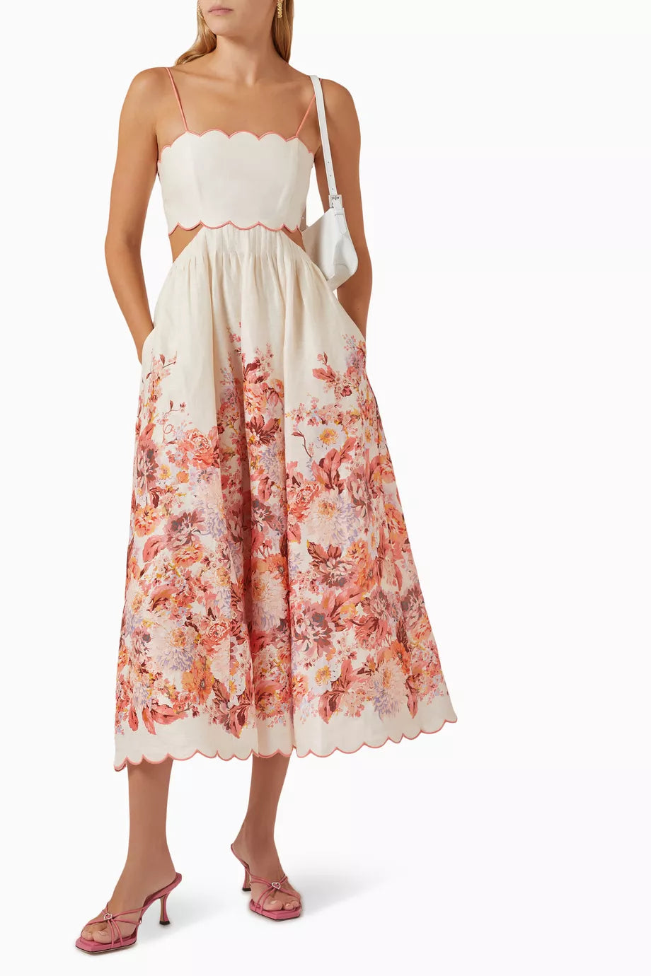 Indulge in the luxury of the Devi Scallop Midi Dress in Linen by Zimmermann. With its vibrant floral print, airy linen fabric, and intricate embroidered scalloped edging, this dress exudes effortless elegance. The flared silhouette, waist cut-outs, and lace-up back provide a playful yet sophisticated touch. Perfect for a summer garden party.