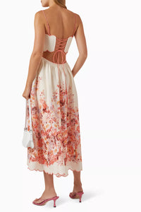 Indulge in the luxury of the Devi Scallop Midi Dress in Linen by Zimmermann. With its vibrant floral print, airy linen fabric, and intricate embroidered scalloped edging, this dress exudes effortless elegance. The flared silhouette, waist cut-outs, and lace-up back provide a playful yet sophisticated touch. Perfect for a summer garden party.