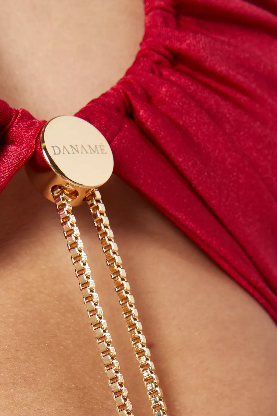 The Genis Cut-out Maxi Dress by Daname redefines evening elegance with its striking high neckline and sleeveless silhouette that flatters the modern woman. A daring front cut-out, adorned with a luxe gold-tone toggle chain, creates an eye-catching focal point that sets this piece apart from traditional formal wear. The graceful flared hem adds movement and dimension, making it perfect for those who want to make a sophisticated statement. 