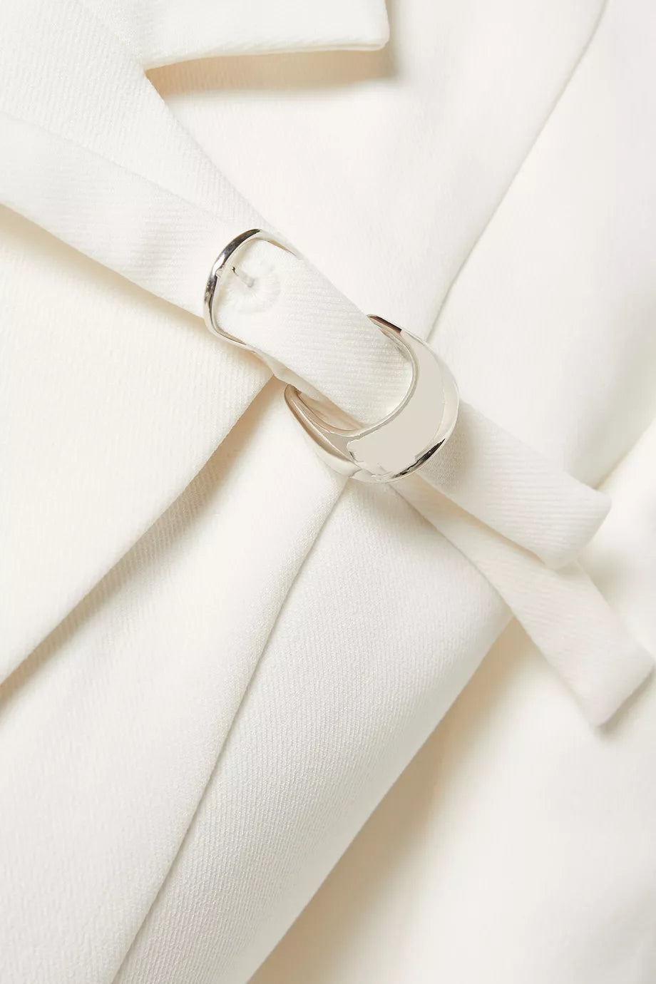 The Talgo Bar Suit Blazer Coat by Chats C.Dam is your essential layering piece for effortless style. This tailored twill-suiting blazer features a sharp notched lapel, streamlined front closure, and distinctive buckled strap detail that elevates any outfit. Whether you're rushing through your morning or transitioning from office to evening, pair it with pumps for polished sophistication or heeled boots as the season turns cooler. 