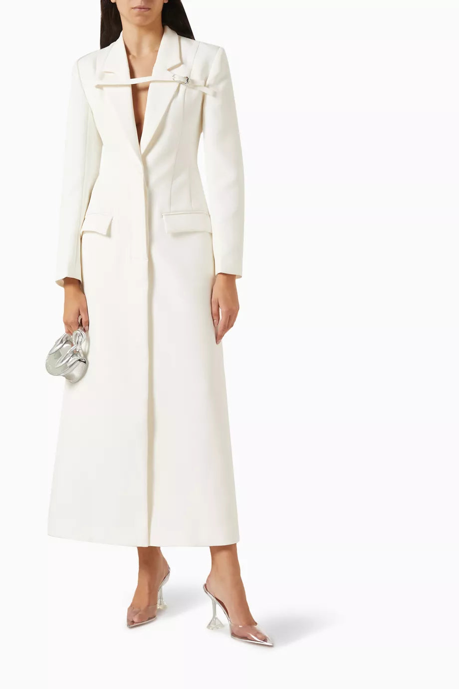 The Talgo Bar Suit Blazer Coat by Chats C.Dam is your essential layering piece for effortless style. This tailored twill-suiting blazer features a sharp notched lapel, streamlined front closure, and distinctive buckled strap detail that elevates any outfit. Whether you're rushing through your morning or transitioning from office to evening, pair it with pumps for polished sophistication or heeled boots as the season turns cooler. 