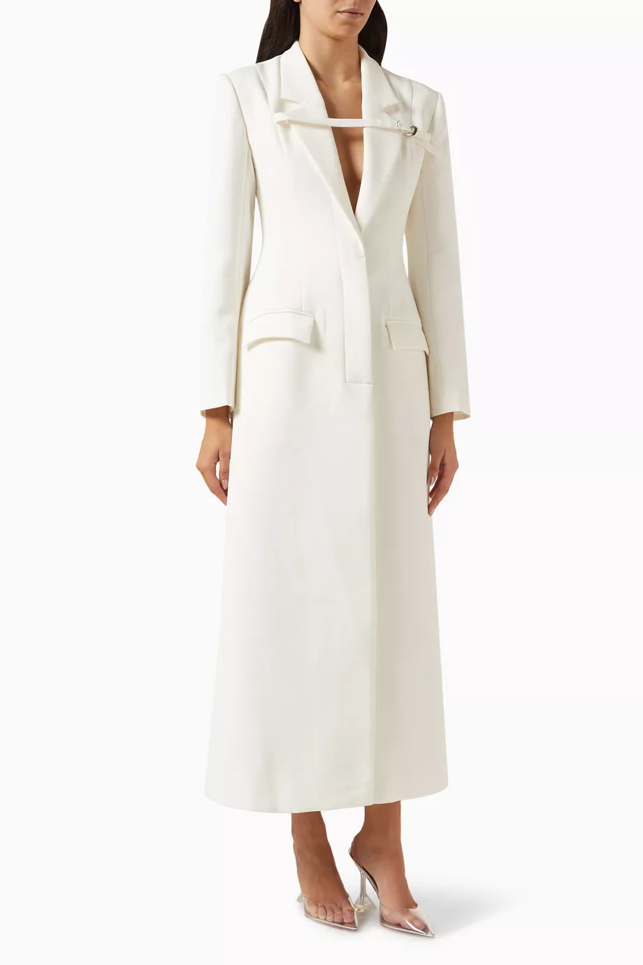 The Talgo Bar Suit Blazer Coat by Chats C.Dam is your essential layering piece for effortless style. This tailored twill-suiting blazer features a sharp notched lapel, streamlined front closure, and distinctive buckled strap detail that elevates any outfit. Whether you're rushing through your morning or transitioning from office to evening, pair it with pumps for polished sophistication or heeled boots as the season turns cooler. 