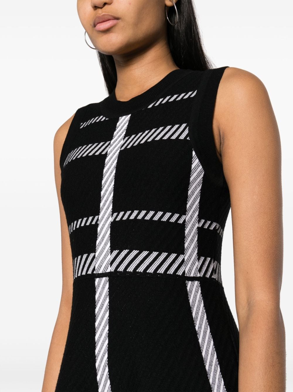 Elevate your style with the Dorothee Schumacher Check-pattern Sleeveless Dress. This dress features a striking check-pattern design that is both classic and modern. The sleeveless cut and lightweight fabric make it perfect for any occasion. Make a statement and turn heads in this timeless and chic piece!