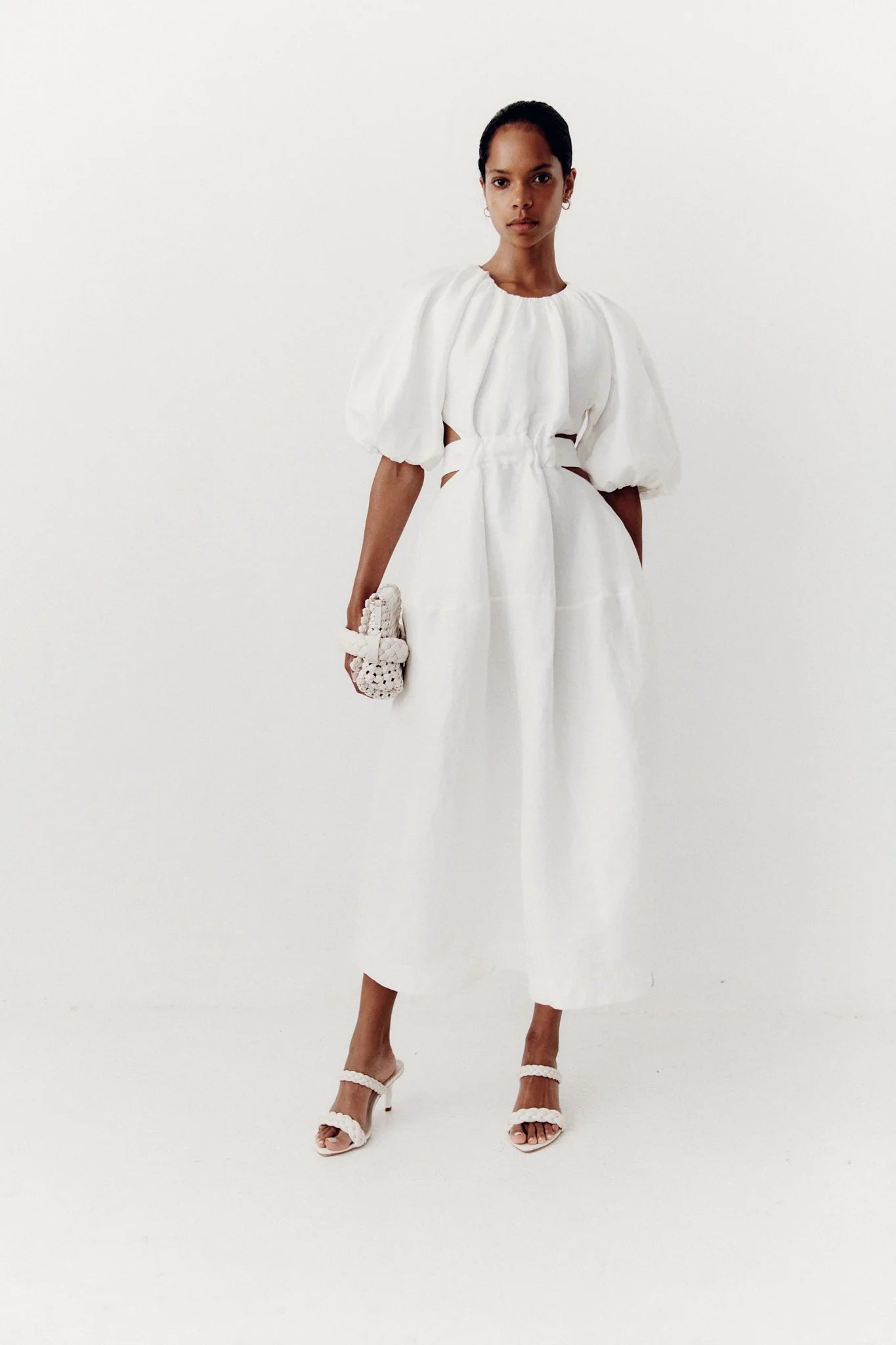 It's hard to resist the charm of Aje's 'Mimosa' dress silhouette. Made from a lightweight linen blend with a cotton lining for added opacity, the dress includes puffed sleeves, a fitted bodice, and waist cutouts. Easily pair it with mules or strappy sandals for a stylish look.