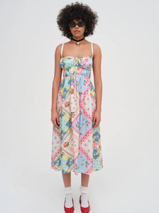 Introducing the Cassandra Midi Dress by For Love & Lemons, your must-have for a nostalgic festival look. This blue apron dress is inspired by patchwork quilts and handkerchiefs found at Grandma's house, and features scrunchy straps, a ruched bodice, and a charming rosette. Rock it and relive the good ol' days.