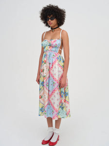 Introducing the Cassandra Midi Dress by For Love & Lemons, your must-have for a nostalgic festival look. This blue apron dress is inspired by patchwork quilts and handkerchiefs found at Grandma's house, and features scrunchy straps, a ruched bodice, and a charming rosette. Rock it and relive the good ol' days.