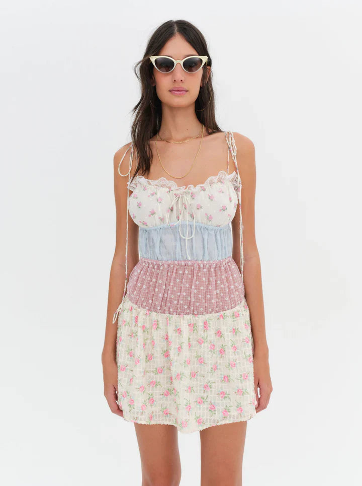 Introducing the Elula Mini Dress from For Love and Lemons. Experience the nostalgic charm of summer Sundays and countryside living with its vintage-inspired patchwork design. The lace ruffle neckline adds a touch of elegance to this timeless sundress. Embrace the carefree and effortless style all season long.