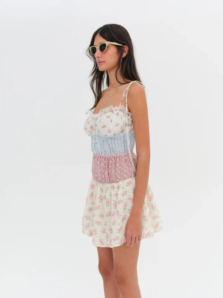 Introducing the Elula Mini Dress from For Love and Lemons. Experience the nostalgic charm of summer Sundays and countryside living with its vintage-inspired patchwork design. The lace ruffle neckline adds a touch of elegance to this timeless sundress. Embrace the carefree and effortless style all season long.