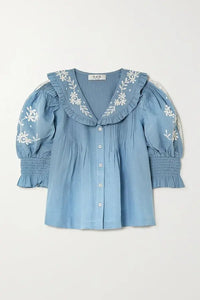 Introducing the Kyla Embroidered Cotton Blouse by Sea. This vintage-inspired blouse will add an air of sophistication to your wardrobe. Made with a breathable cotton and linen blend, it features delicate floral embroidery, ruffled collar, and pintucked details. Transform your look with this charming and unique piece.