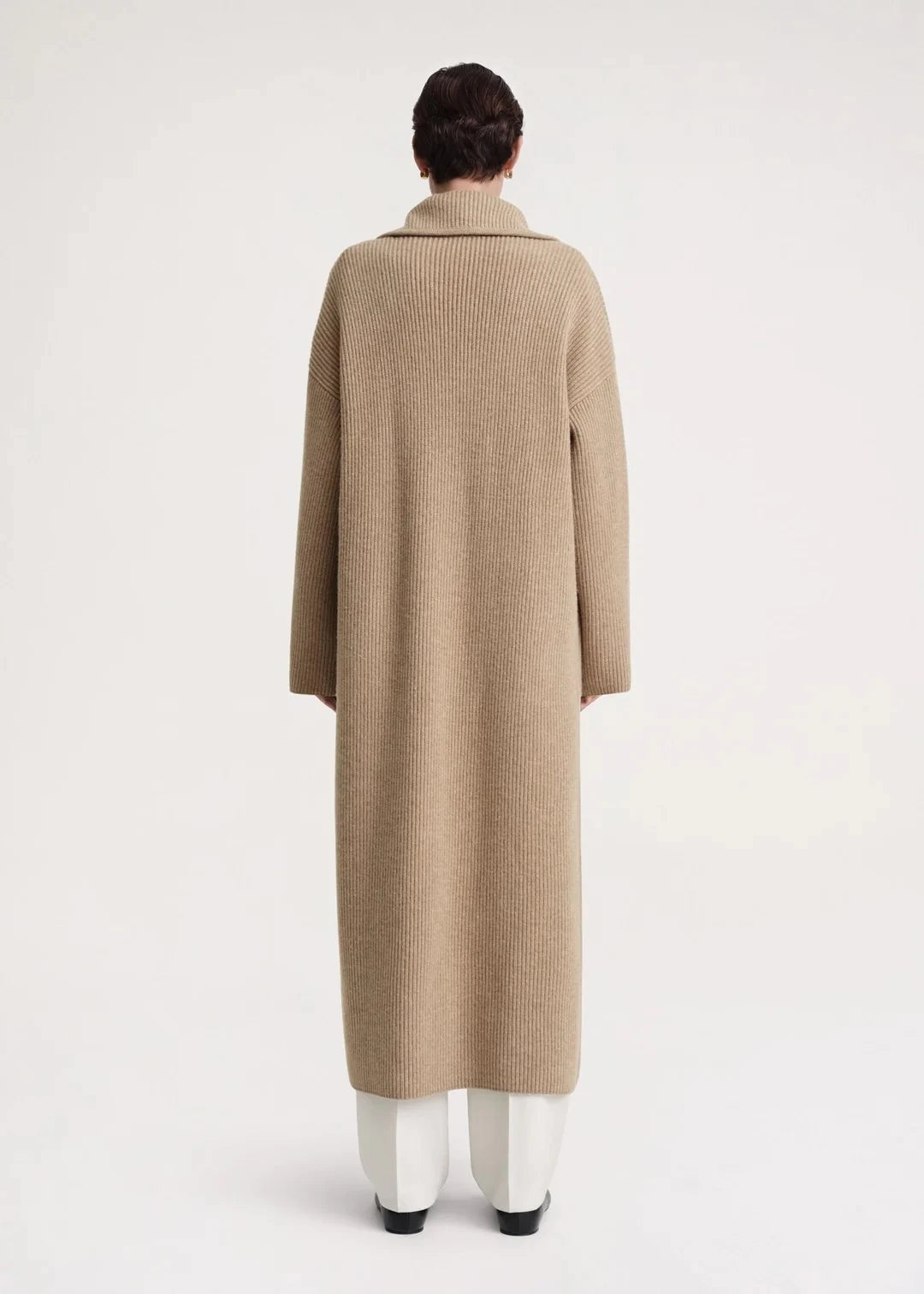 Introducing the Totême Rib Knit Coat, a luxurious and elegant addition to any wardrobe. Keep warm in style with this sophisticated tan coat, boasting a rib knit design for added texture. Elevate your look and feel exclusive in this timeless piece.