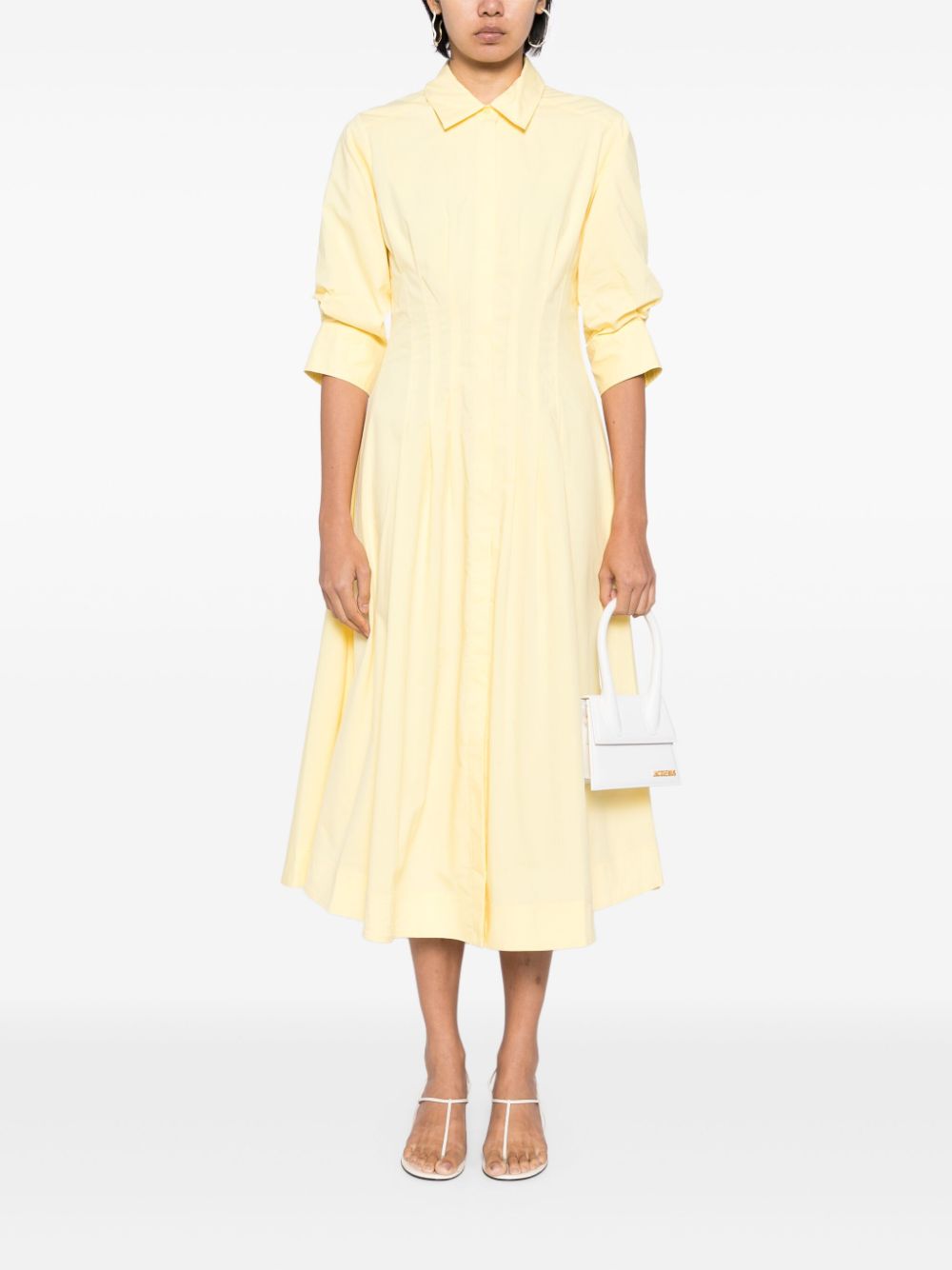 Introducing the Simkhai Jazz Midi Dress in a striking sulfur yellow. Made with a comfortable cotton blend, this dress features pintuck detailing and a straight-point collar. The three-quarter length puff sleeves and flared skirt add a touch of femininity. With a concealed front button fastening, buttoned-cuff sleeves, and two side inset pockets, this dress is both functional and stylish. Complete with full lining and a midi-length straight hem, this dress is perfect for any occasion.