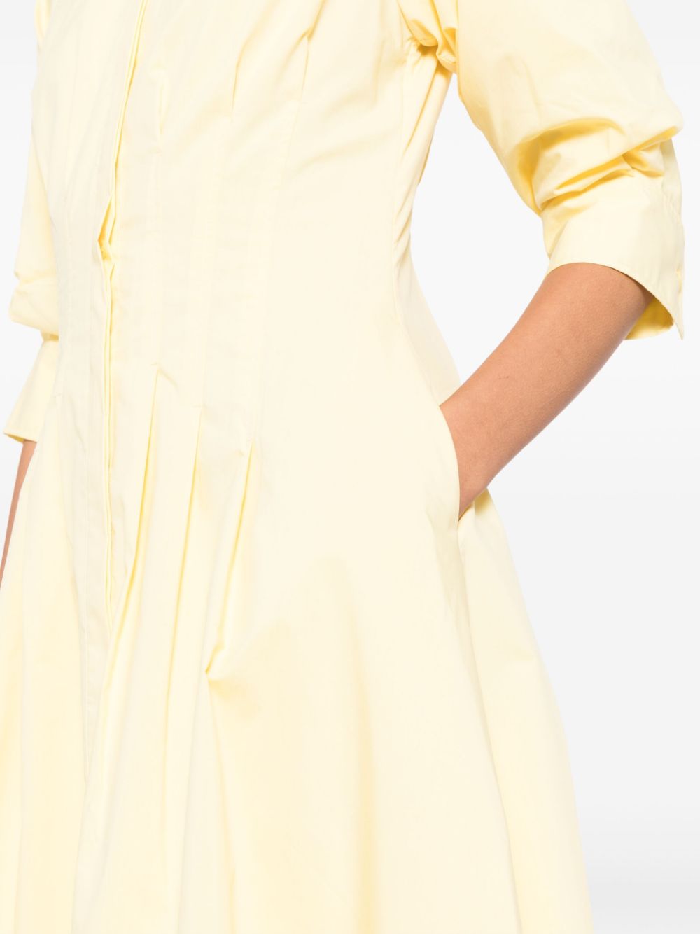 Introducing the Simkhai Jazz Midi Dress in a striking sulfur yellow. Made with a comfortable cotton blend, this dress features pintuck detailing and a straight-point collar. The three-quarter length puff sleeves and flared skirt add a touch of femininity. With a concealed front button fastening, buttoned-cuff sleeves, and two side inset pockets, this dress is both functional and stylish. Complete with full lining and a midi-length straight hem, this dress is perfect for any occasion.