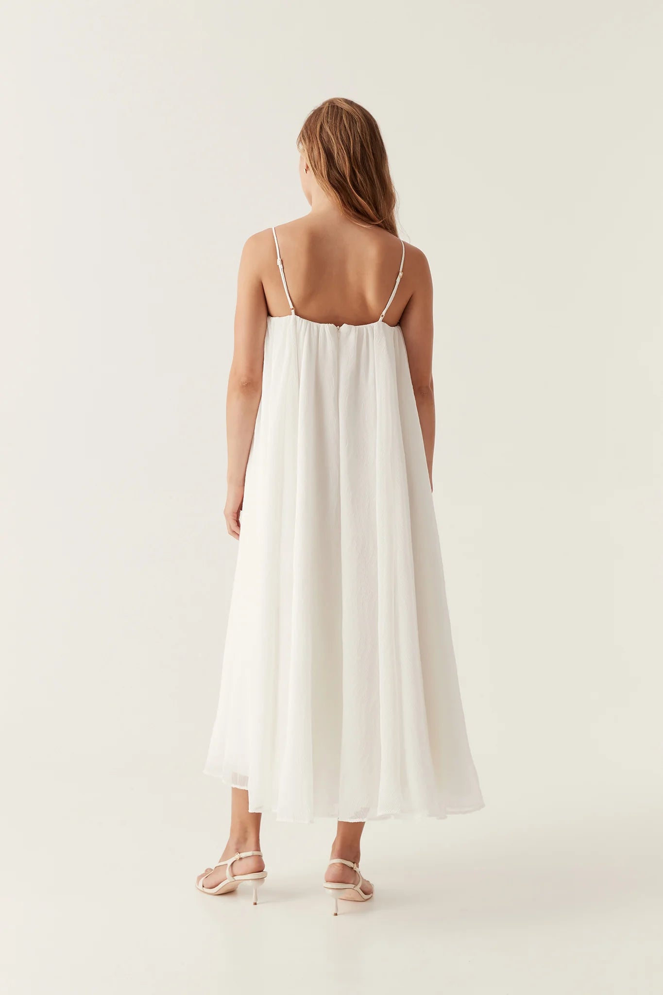 Introducing the Filigree Sweetheart Midi Dress by AJE, the epitome of elegance and luxury. Designed with a relaxed fit and adjustable straps, this dress effortlessly flatters your silhouette. The wired curve neckline and whipstitch details add a touch of sophistication, while the voluminous smock skirt and permanent plissé pleating throughout create a whimsical flow.