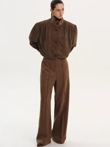 This ruched suede bomber jacket combines classic style with modern details. Its boxy shape and padded shoulders give a confident edge, while the stand collar and gathered pleats add subtle sophistication. The softly structured waistband offers a gentle blouson effect, creating a relaxed yet polished silhouette. Fully lined for comfort, this jacket is perfect for elevating any outfit with effortless charm.