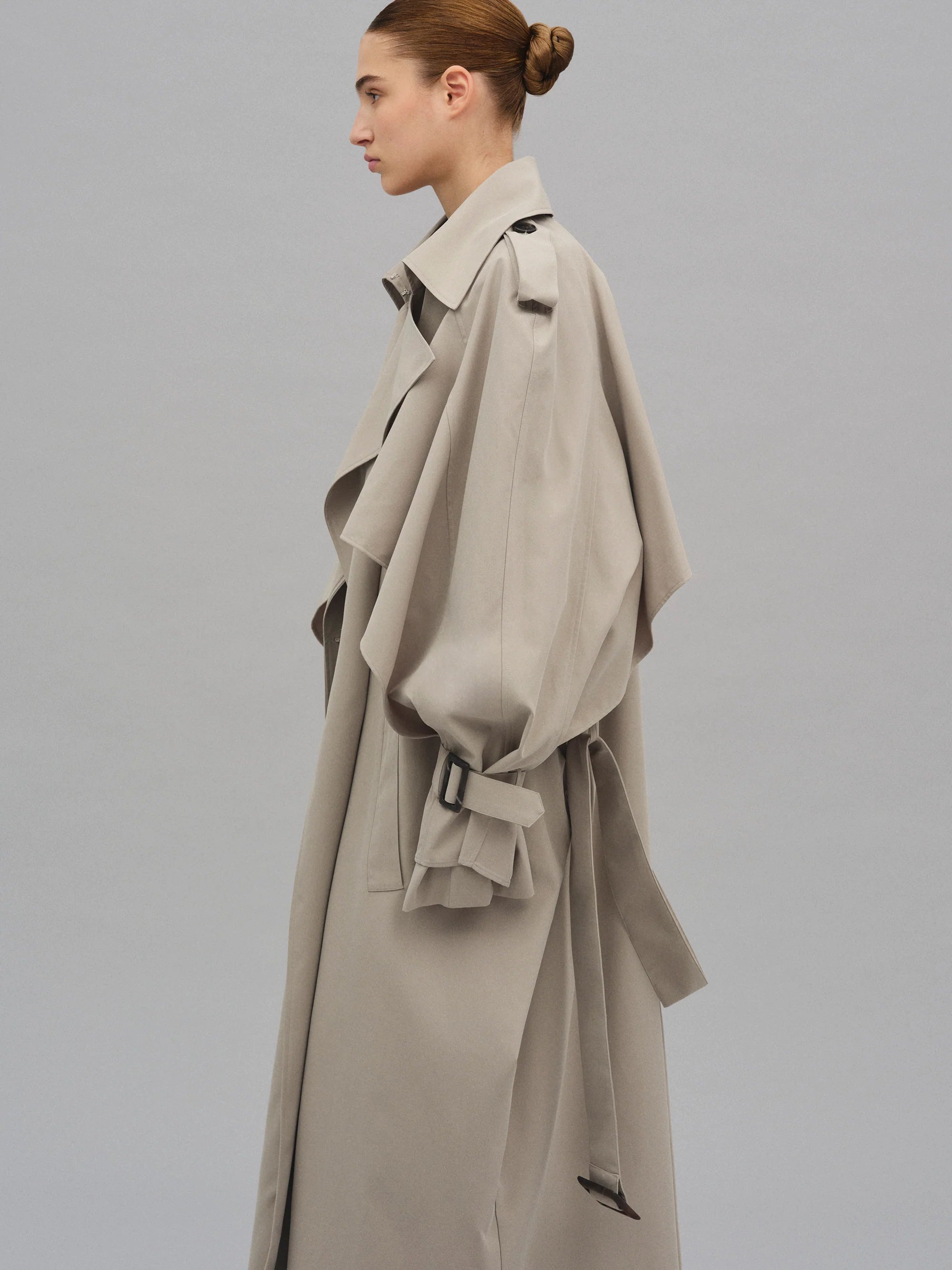 This Caped Trench Coat elevates the traditional silhouette with voluminous cape-like accents draped from the shoulders and sleeves, blending architectural boldness with classic refinement. Fully lined for a polished finish, it offers both visual impact and lasting comfort, making it a sophisticated addition to any wardrobe.