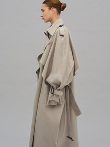 This Caped Trench Coat elevates the traditional silhouette with voluminous cape-like accents draped from the shoulders and sleeves, blending architectural boldness with classic refinement. Fully lined for a polished finish, it offers both visual impact and lasting comfort, making it a sophisticated addition to any wardrobe.