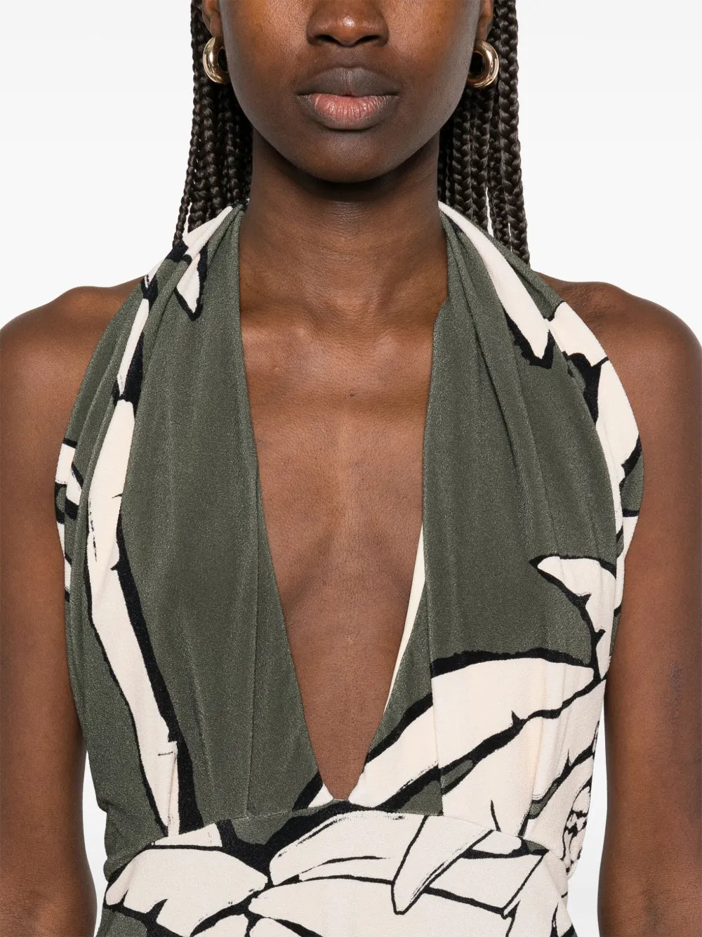 The Oceanic Mantra midi dress by Johanna Ortiz features an elegant olive green hue complemented by a halterneck design with a distinctive crossover strap detail, offering both comfort and visual interest. Its straight hemline creates a sleek silhouette, making it a sophisticated choice for elevated daytime or evening occasions.