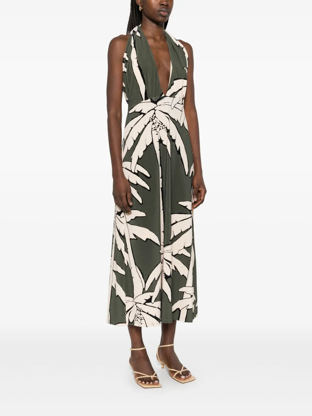 The Oceanic Mantra midi dress by Johanna Ortiz features an elegant olive green hue complemented by a halterneck design with a distinctive crossover strap detail, offering both comfort and visual interest. Its straight hemline creates a sleek silhouette, making it a sophisticated choice for elevated daytime or evening occasions.