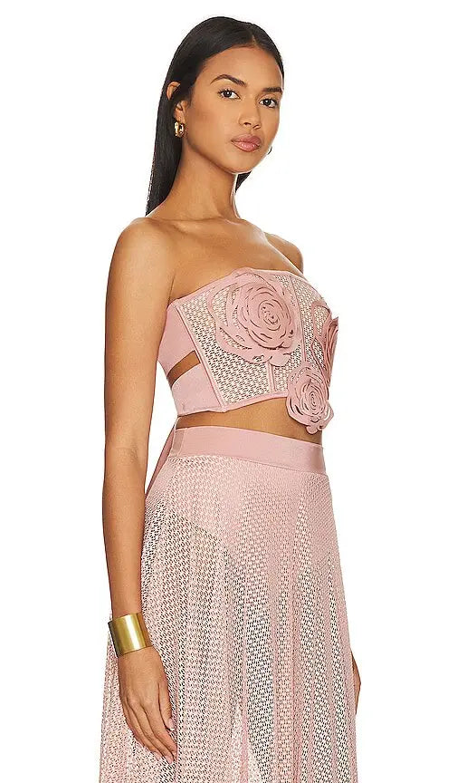 This versatile two-piece set features a strapless design and resembles a corset, exuding elegance and sophisticated style. Its fibers provide excellent elasticity, ensuring a comfortable fit as it conforms to the body's shape. Pair with the matching bikini bottoms or Jardin de Rosas skirt for a complete look, or wear it with this lightweight, flowy skirt that showcases the leg's silhouette through small cuts.