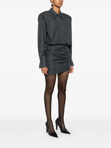 The Narine mini dress by Retrofete features a sophisticated charcoal and light grey pinstripe pattern, crafted with expert tailoring. It includes a concealed front button fastening and side zip for a seamless look, while shoulder pads and ruched detailing add structured elegance. The dress is finished with a pointed flat collar, long sleeves with buttoned cuffs, a straight hem, and full lining for comfort and quality. Ideal for those seeking a refined, modern silhouette with subtle detailing.