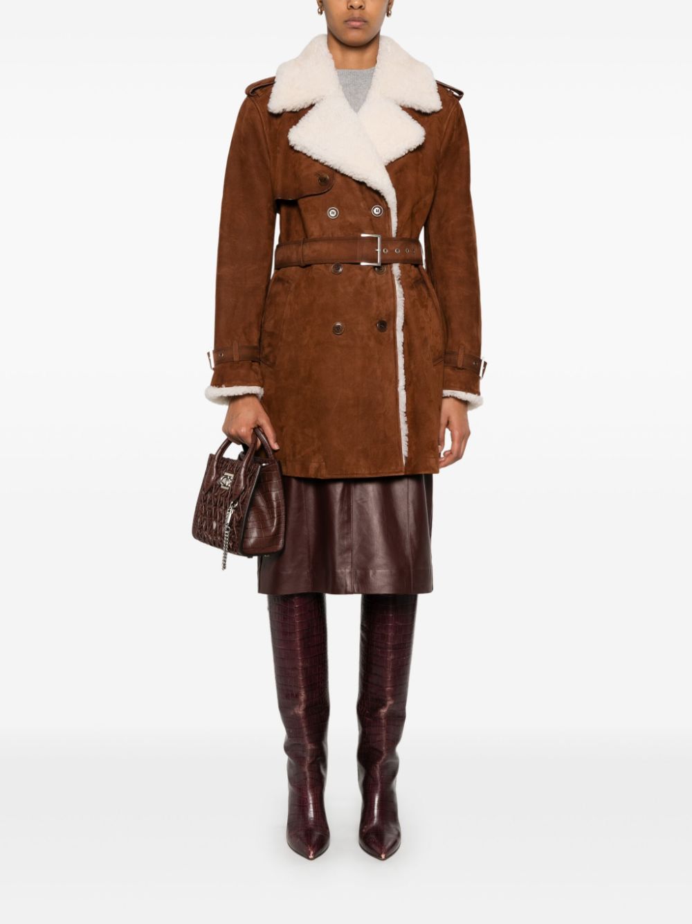 Take on the world in the bold and adventurous Suede Shearling Coat by Ermanno Scervino. Hand-dyed and crafted from luxurious suede, this double-breasted coat features military-inspired buttons and a striking trench coat design with shoulder loops and strap cuffs. Its light gold galvanic plating adds a touch of daring sophistication.