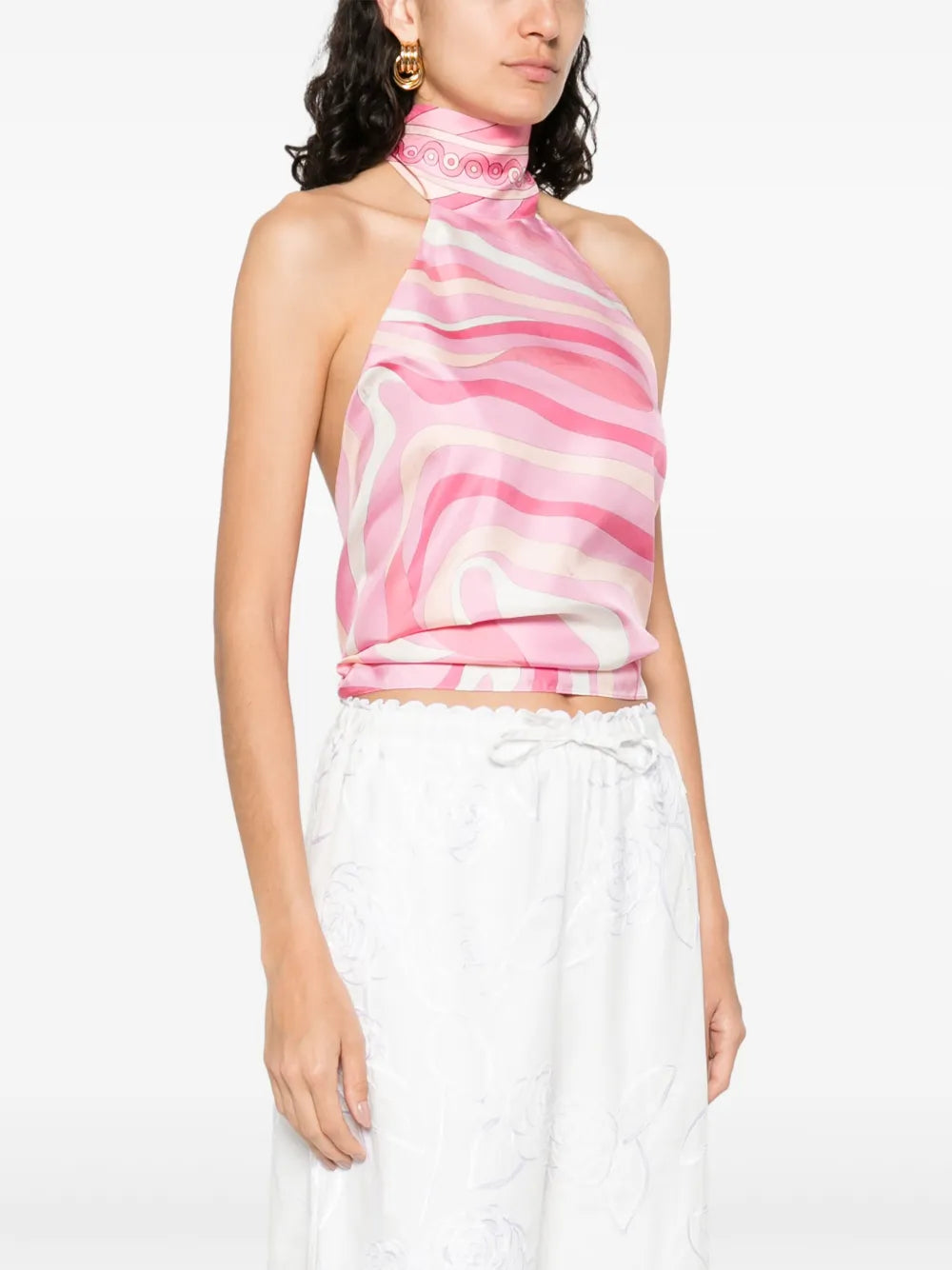 This top from Pucci showcases the brand’s signature Marmo motif rendered in bold, psychedelic prints with vibrant palettes. Crafted from luxurious silk, it offers a smooth, lustrous finish that enhances the rich colors. The elegant halter neckline adds a refined silhouette, making it a standout piece that combines artistic design with sophisticated wearability.
