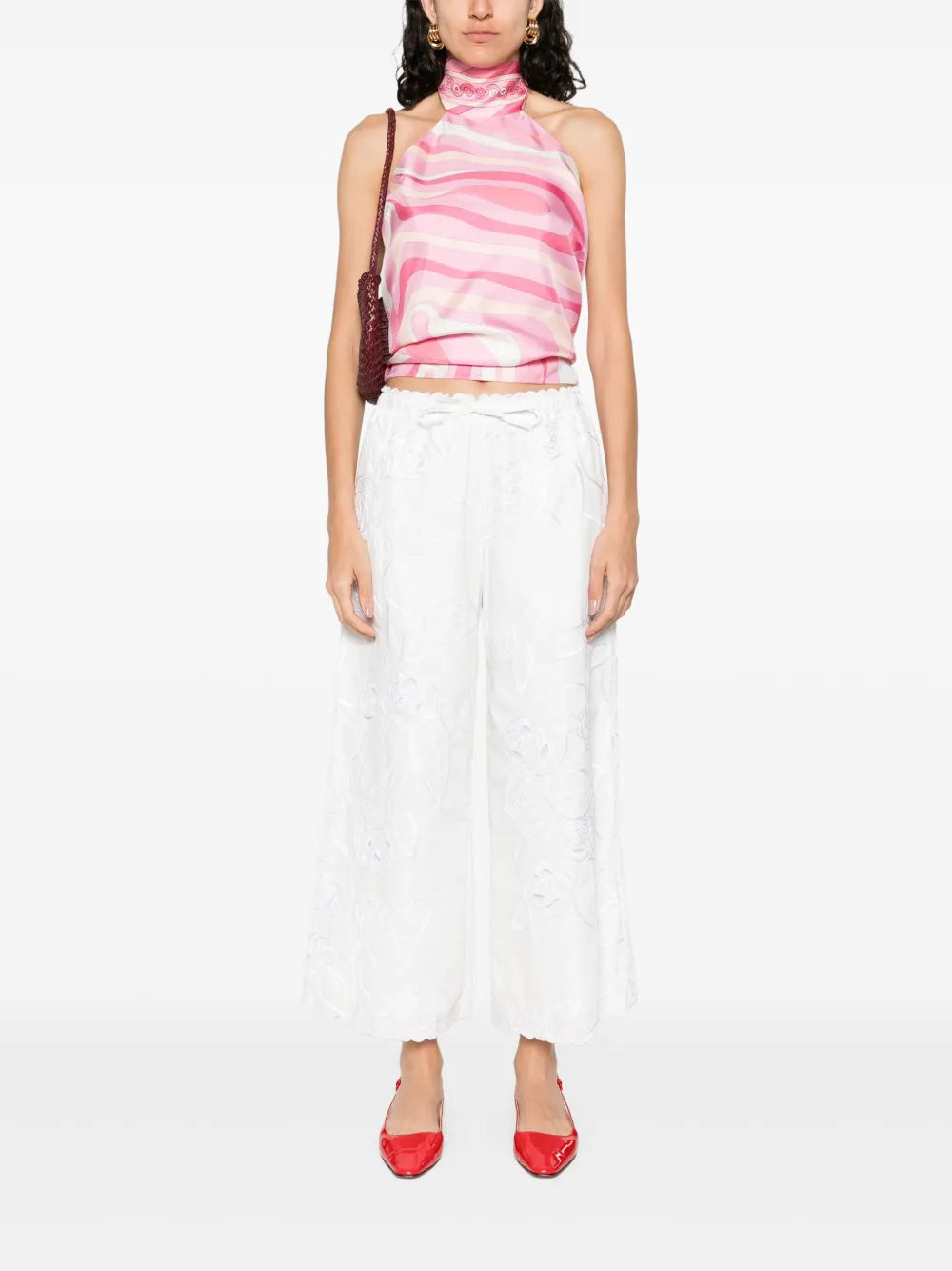 This top from Pucci showcases the brand’s signature Marmo motif rendered in bold, psychedelic prints with vibrant palettes. Crafted from luxurious silk, it offers a smooth, lustrous finish that enhances the rich colors. The elegant halter neckline adds a refined silhouette, making it a standout piece that combines artistic design with sophisticated wearability.