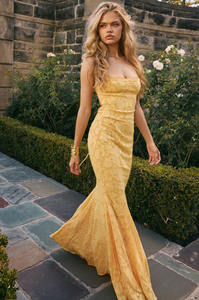 Cut from delicate burnout lace, the Joan Lace Dress elegantly celebrates femininity with refined craftsmanship. Its dainty trimmed neckline and straps lead to an open back fastened with satin ties, allowing a personalized fit. The dress gracefully skims the figure, extending into a floor-length maxi silhouette that flares into a sophisticated godet skirt, adding movement and timeless glamour to this exquisite piece.