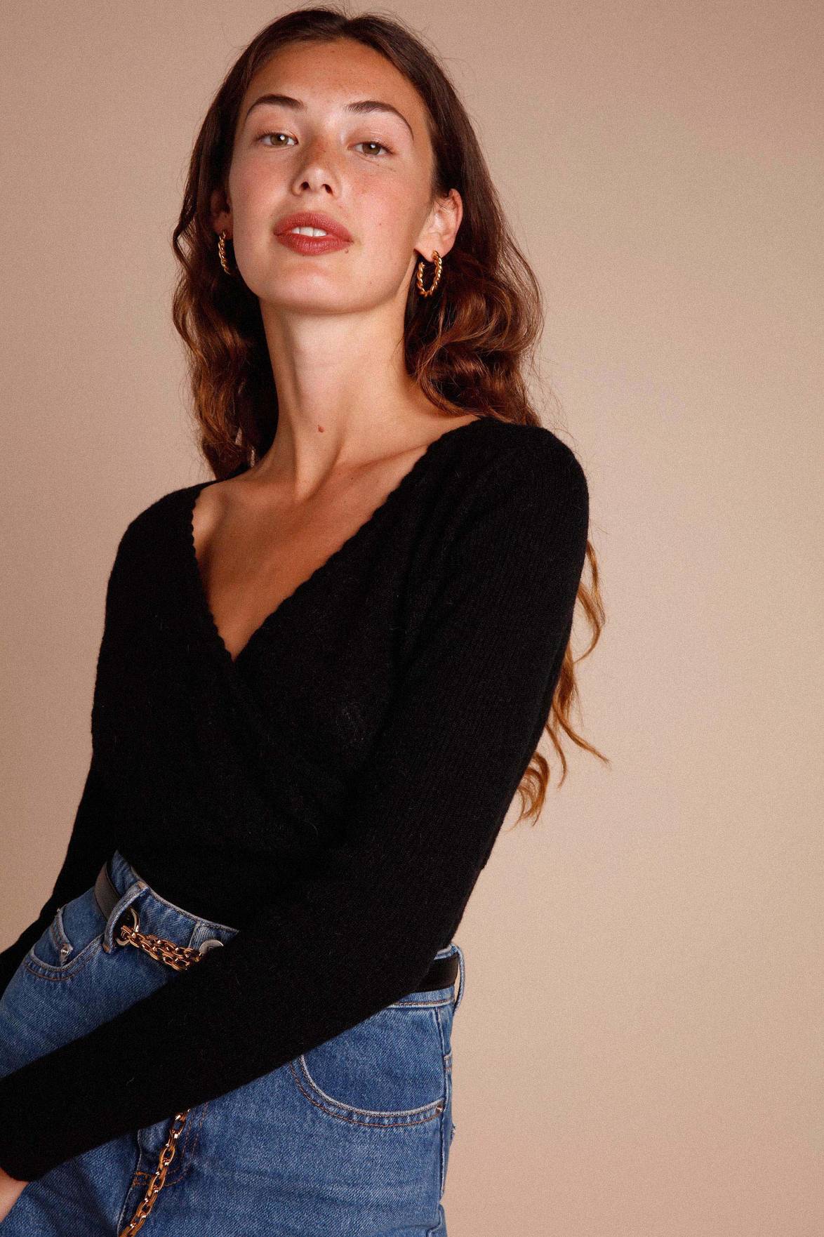 Elevate your style with the Jersey Zoeline! Crafted with a textured punto negro fabric, this top features a flattering "V" neckline, unique crossover design, and comfortable long sleeves. Experience the perfect combination of sophistication and comfort in one garment.