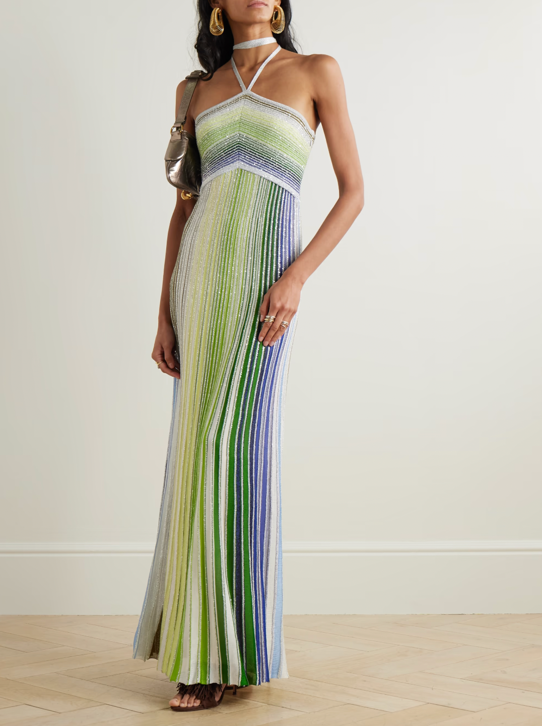 Missoni’s Sequin-embellished Metallic Crochet-knit Halterneck Maxi Dress elevates occasion dressing with vibrant style. Crafted in Italy with metallic threads, its vivid striped pattern catches the eye, while shimmering sequins add an elegant sparkle. The silver halterneck strap beautifully frames the collarbones, making this dress a stunning choice for any special event.