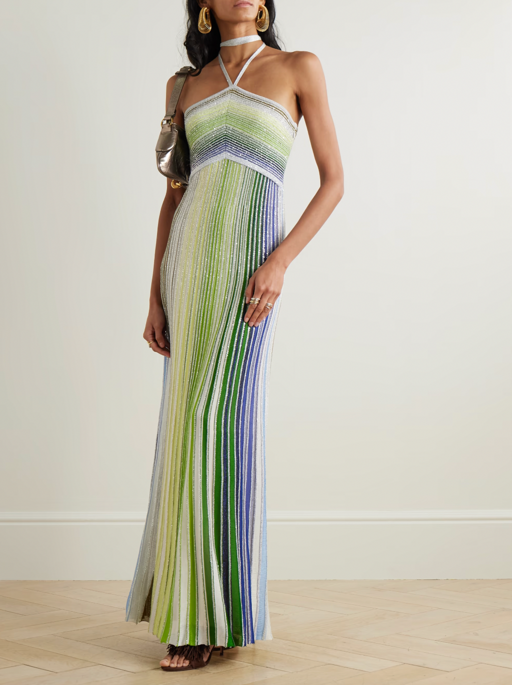 Missoni’s Sequin-embellished Metallic Crochet-knit Halterneck Maxi Dress elevates occasion dressing with vibrant style. Crafted in Italy with metallic threads, its vivid striped pattern catches the eye, while shimmering sequins add an elegant sparkle. The silver halterneck strap beautifully frames the collarbones, making this dress a stunning choice for any special event.