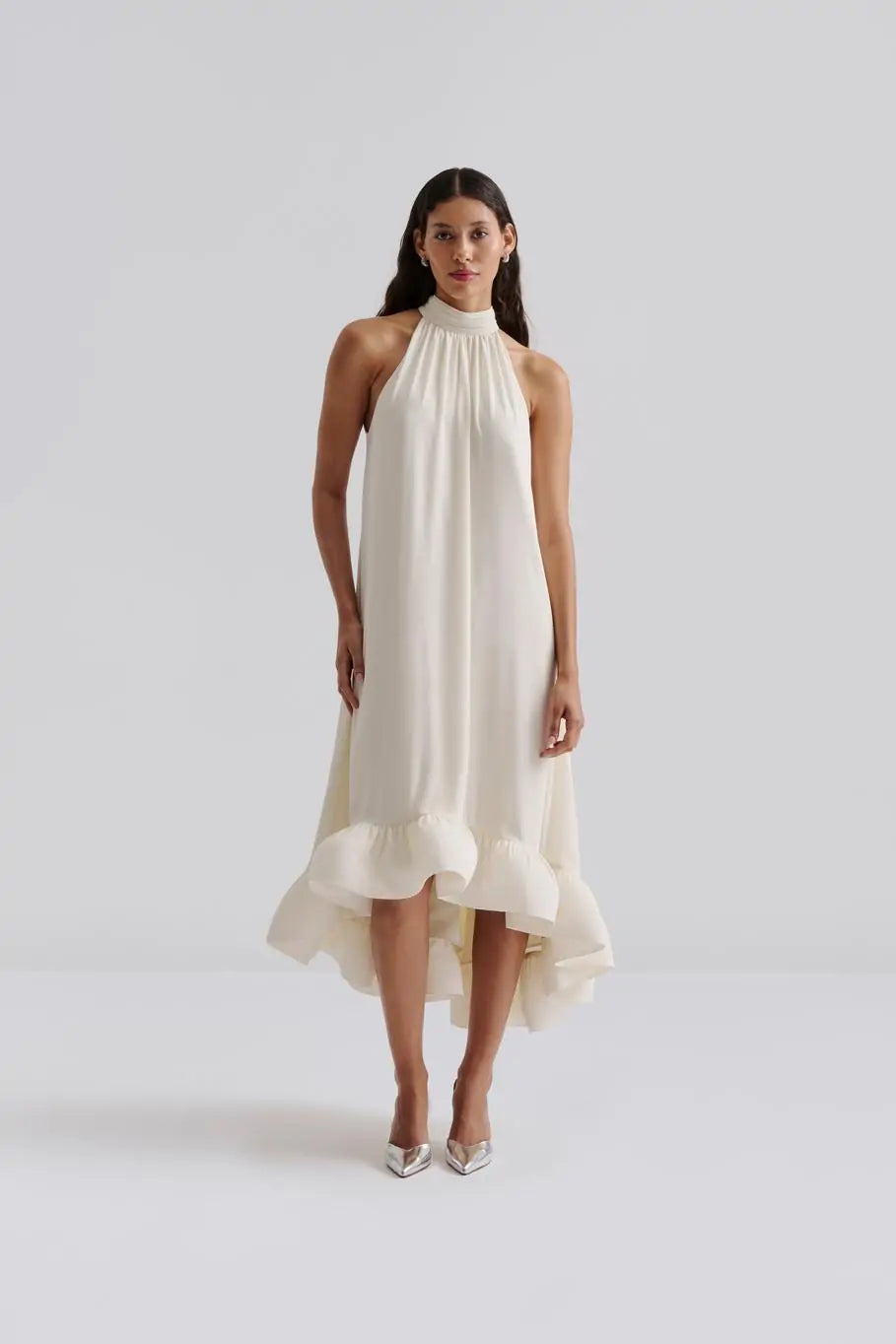 Das Sabrina Halterneck Brautkleid kombiniert zeitlose Eleganz mit romantischem Charme. Das leichte Neckholder-Maxikleid mit offenem Rücken und fließendem, sanft gerüschtem Rock sorgt für eine feminine Silhouette und einen unvergesslichen Auftritt. Der Schleifenverschluss am Nacken setzt Ihre Schultern gekonnt in Szene und macht es zur perfekten Wahl für standesamtliche Trauungen, Sommerhochzeiten oder festliche Anlässe. Fühlen Sie sich mühelos schön und strahlen Sie an Ihrem besonderen Tag.