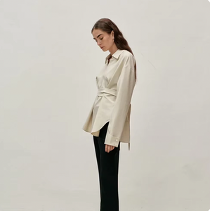 This soft and stylish cotton blouse features a unique tie band at the waist, adding a touch of femininity to your wardrobe. The standing collar and button closure give it a sophisticated look, while the regular fit ensures comfort. Elevate your outfit with this versatile tie-waist blouse!