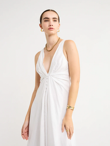 Adorn yourself with the elegance of the Sabrina Linen Maxi Dress in White. Crafted from Flax Linen fabrication for a relaxed easy fit, this maxi dress features a plunging neckline, a gathered twist front feature, functional linen-covered buttons, and a V-line open back with spaghetti tie fastening. With a graceful full skirt, this dress will be your go-to choice for summer getaways, birthday celebrations and refined holiday dressing.