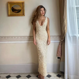 Dress to impress with the luxurious Carena Maxi Dress. Its creme plunge neckline and intricate floral appliqué adornment exude elegance and sophistication. Perfect for any special occasion, this dress will make you stand out in a sea of basic styles. Elevate your wardrobe with this must-have piece.