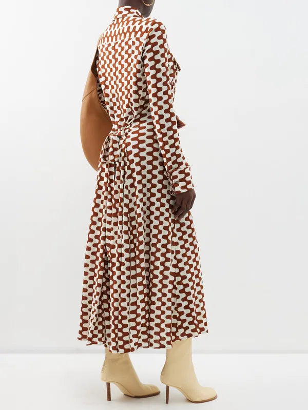 Embrace retro chic with Proenza Schouler's Printed-Jersey Maxi Shirt Dress. The brown and cream zigzag motif adds a playful touch to this sophisticated dress, made from comfortable jersey with a flattering tie-back waist and elegant fold French cuffs. Elevate your wardrobe with this exclusive piece.