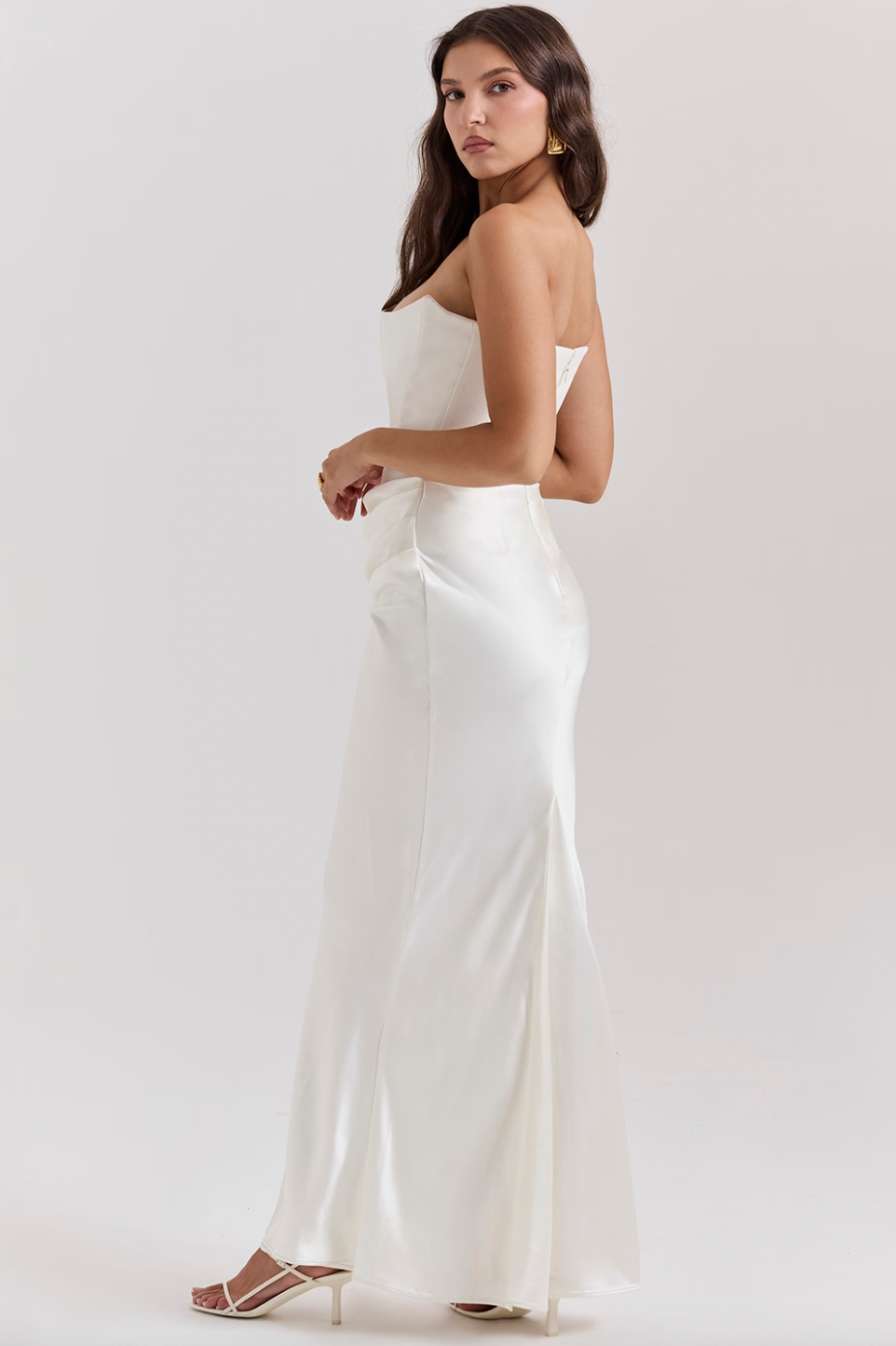 Indulge in luxury with the Ivory Strapless Corset Dress. Perfect for any high-octane occasion, this dress is crafted from stretch crepe and ultra luxe satin. The strapless neckline and boned bodice cinch the waist, while the beautifully draped skirt creates a striking silhouette. Make a statement with its flattering dress.