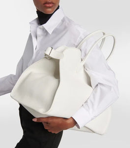 Introducing the Soft Margaux 17 Bag in White by The Row, now in luxurious grained leather. Handcrafted in Italy, this spacious tote is the perfect blend of style and comfort. Twin rolled handles, gusseted sides, and toggle closure make it both functional and fashionable. Upgrade your everyday with this must-have accessory.