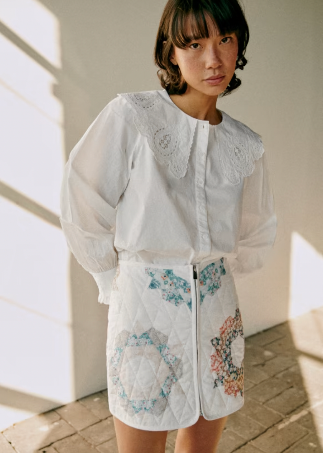 The Flavie Shirt by Sezane combines timeless elegance with a standout design featuring a large embroidered collar that adds a touch of sophistication to your look. Its long sleeves and buttoned front offer both comfort and versatility, making it perfect for dressing up or down. Elevate your wardrobe with this statement piece that effortlessly blends classic style and unique detail.