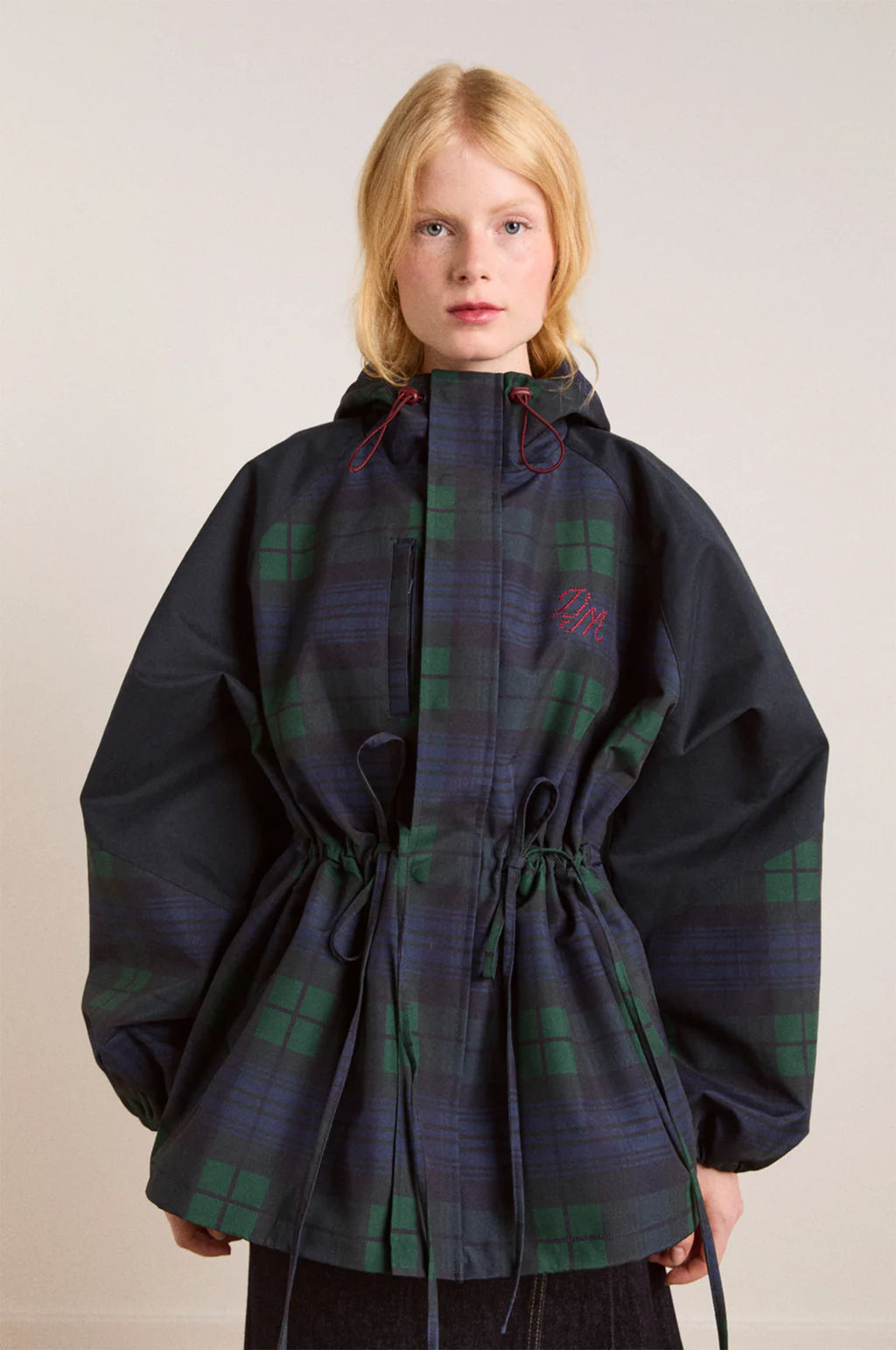 Embrace rainy days with the Liu Coat from Damson Madder, featuring a classic Black Watch tartan design crafted from shower-resistant fabric. Its balloon-style cuffs, adjustable hood, and cinchable waist offer both comfort and a flattering silhouette, while signature 'DM' embroidery adds a touch of distinction. Equipped with practical pockets and thoughtful details, this coat effortlessly combines style and functionality, making it the perfect shield against wet weather.