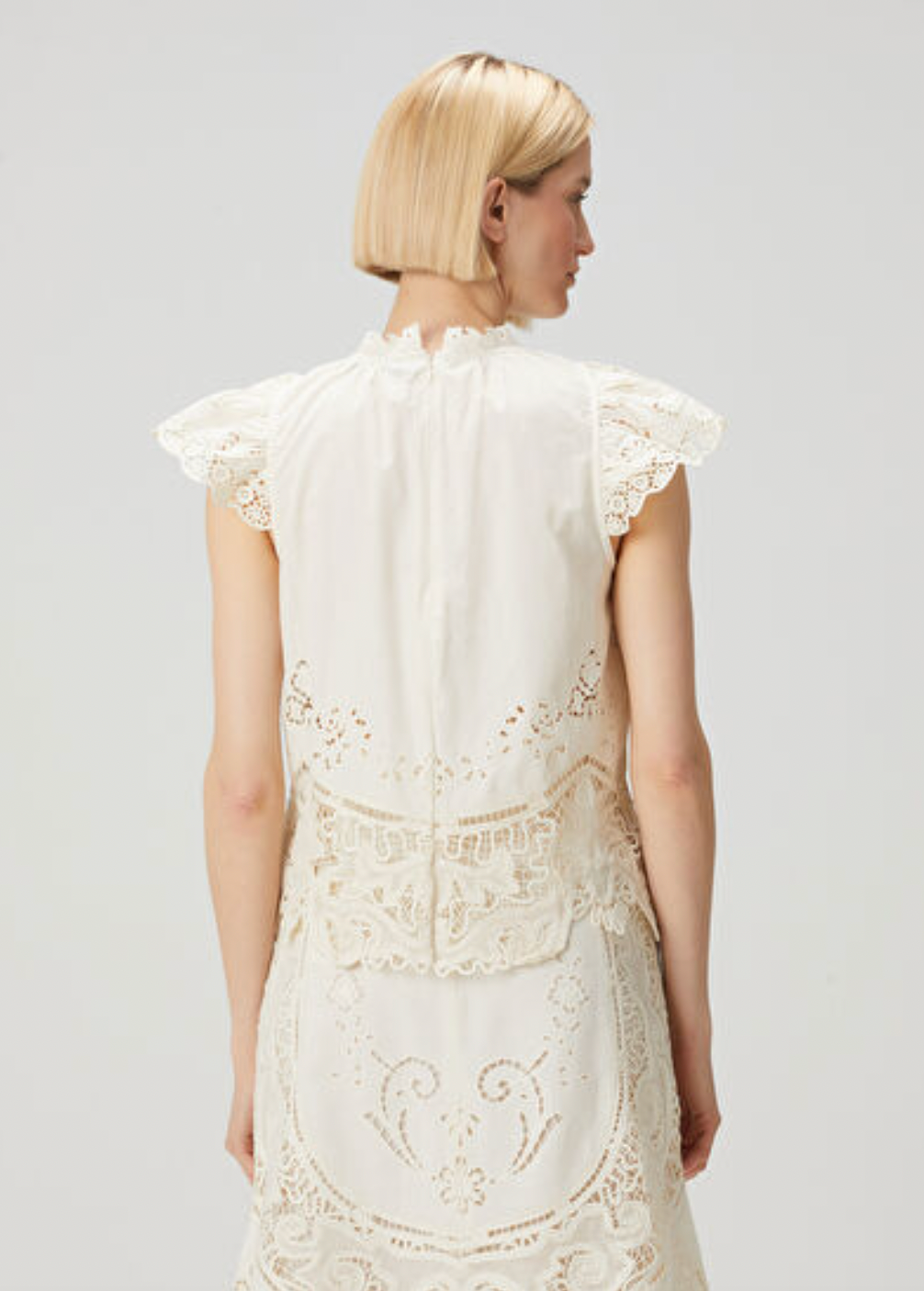 Elevate your wardrobe with the Gianna Bone Lace Blouse by SEA, featuring a refined mandarin collar that adds subtle sophistication. Delicate lace and ruffle details enhance its tank top design, blending elegance with breathable comfort. Ideal for layering or wearing alone, this blouse offers a polished look perfect for both professional settings and stylish casual occasions.