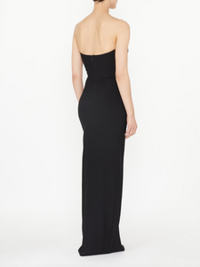This black strapless evening dress by NENSI DOJAKA features a fitted silhouette that accentuates your figure with elegance. Crafted from high-quality Italian material, it showcases a distinctive keyhole neckline and a high slit, adding a refined and striking edge. The zip fastening at the back ensures a secure and tailored fit, making it an exceptional choice for sophisticated occasions.