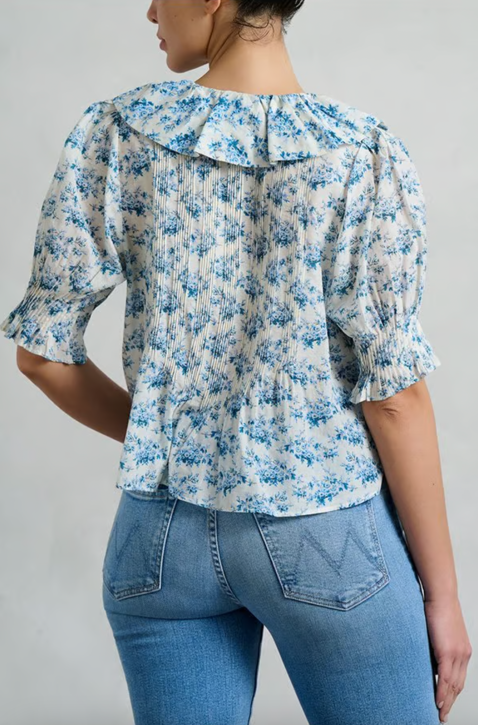The Henri Top is a stunning blend of romantic Victorian aesthetics and modern sophistication. Made from soft, lightweight organic cotton voile, it features a plunging V-neckline adorned with cascading lace-trimmed ruffles. Delicate clustered pintucks accent the yoke and puffed sleeves, while hidden starburst buttons add a unique touch. Perfect for both casual outings and special occasions, this blouse effortlessly elevates any outfit with its vintage charm and playful elegance.