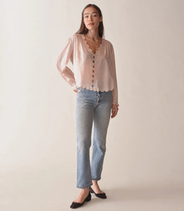 Dare to stand out in the Elayne Top from Doen, with its plunging V-neck, playful cutouts, and textured pintucks. Made with soft organic cotton, it features embroidered details, a cropped hem, and an adjustable waist tie. Take on the day with confidence and style!